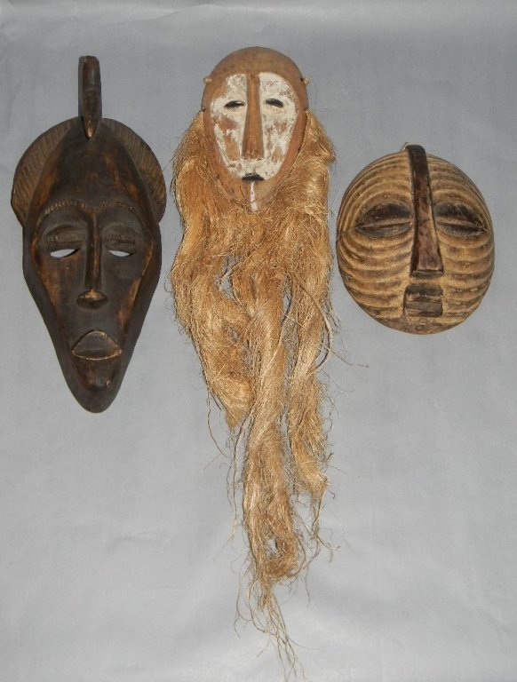 3 CARVED WOOD AFRICAN MASKS IDUMU, PUNU, LUBA: 3 CARVED WOOD AFRICAN MASKS; 1 Punu style with carved crest, 33.2cm (13" l), one round Luba, Kifwebe style mask, 20.32cm (8"l); 1 Lega, Idumu mask withoval face with fiber beard, 50.8cm (20"l). Proven