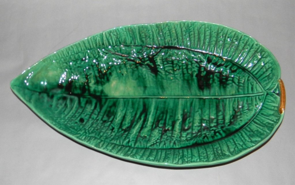 LARGE GEORGE JONES MAJOLICA BANANA LEAF TRAY: LARGE GEORGE JONES MAJOLICA CERAMIC BANANA LEAF TRAY: Large Majolica banana leaf tray on a molded brown twig base. Early impressed Jones mark on base; 1866-1877; 20 3/4" x 11 7/8"; Condition: Free of 