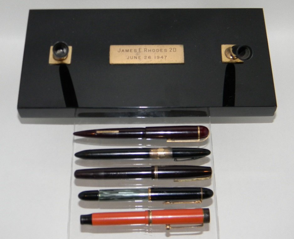 5 FOUNTAIN PENS 14K NIBS AND RHODES PEN STAND: 5 FOUNTAIN PENS AND PEN STAND: Most with 14k Glod Nibs; to include Parker Big Red, Waterman's Ideal with 14k Gold Nib, Eversharp with 14k Gold Nib, Scheaffer's Lifetime with 14k Gold Nib, Reliant Peli