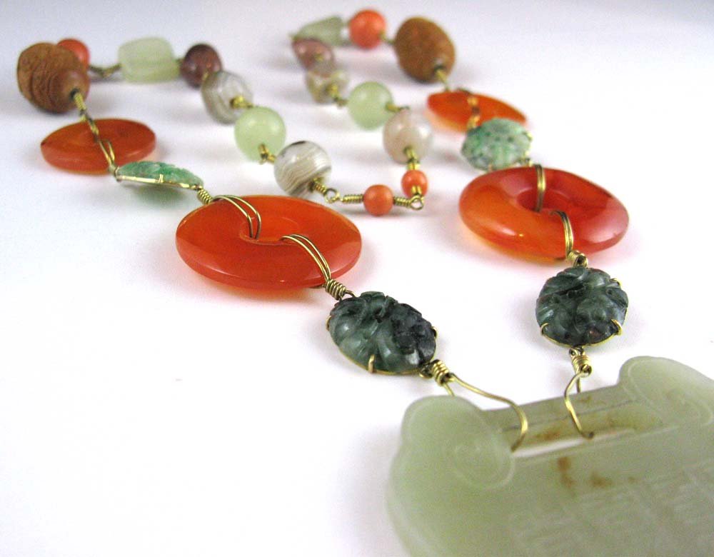 CHINESE 14K GOLD, JADE, CARNELIAN NECKLACE: CHINESE 14K GOLD JADE NECKLACE with jade pendant, carved jade cabochons in 14k gold fittings, carnelian discs and beads of agate and coral, Pendant is 2 1/4\" x 1 7/8\", total length 28\".