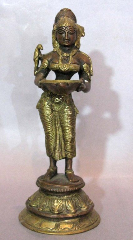 HINDU BRONZE WOMAN WITH OFFERING TRAY: HINDU BRONZE WOMAN WITH OFFERING TRAY: Standing upon a circular, tiered base and holding an offering tray, 9.25" h (23.5 cm).