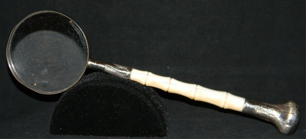 ANTIQUE STERLING AND BONE MAGNYIFYING GLASS: ANTIQUE STERLING AND BONE MAGNYIFYING GLASS: The bone handle carved as bamboo, engraved sterling knop and collar, both marked, "STERLING," 12.5" l (31.75 cm).