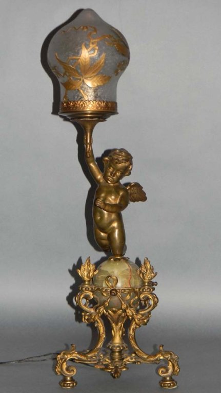19TH C CHERUB LAMP WITH ETCHED CAMEO GLASS SHADE: 19TH C CHERUB LAMP WITH ETCHED CAMEO GLASS SHADE: Torchiere converted to electric, Ormolu metal tri-footed base with grotesque mask mounts on knees supporting bronze ribbons, swags and flaming urns en