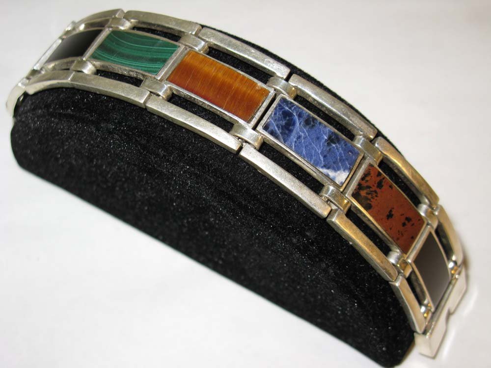 ALICIA DE LA PAZ TAXCO .STERLING & INLAY BRACELET: .950 Sterling silver and stone inlay bracelet by Alicia de la Paz, noted Taxco silversmith. Each of the seven links bears a different semi precious stone flush mounted into silver, included are Onyx, 