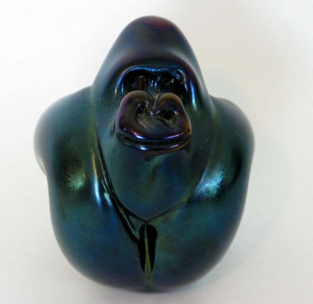 ORIENT & FLUME GORILLA ART GLASS PAPERWEIGHT: Hand pulled, iridescent gorilla form paperweight by Orient & Flume, remnants of paper label on base and etched, "Orient & Flume W1329RA". Measures: 4"h x 3"w. (6-23-06)