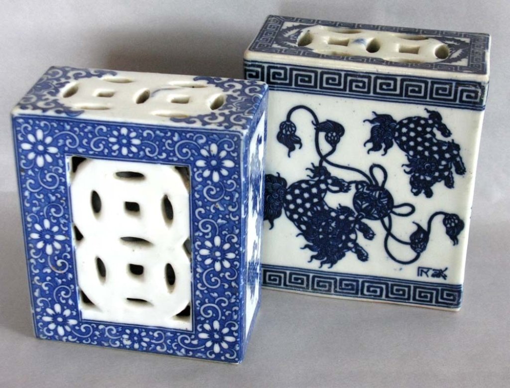 PAIR OF 19TH C. CHINESE CERAMIC OPIUM PILLOWS: A pair of Chinese, ceramic Opium pillows. One with open-work cash design decorated with foo dogs and fret work in blue and white, 5.75"h x 5"w x 2.5"d (14.60cm x 12.7cm x 6.35cm). The second with pier