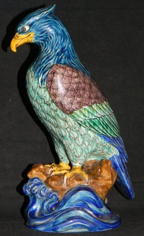 CHINESE GLAZED CERAMIC HAWK BIRD OF PREY: Chinese richly glazed ceramic bird of prey standing on a rock above crashing waves. Bird modeled with an intense stare; 10"h (25.4cm).