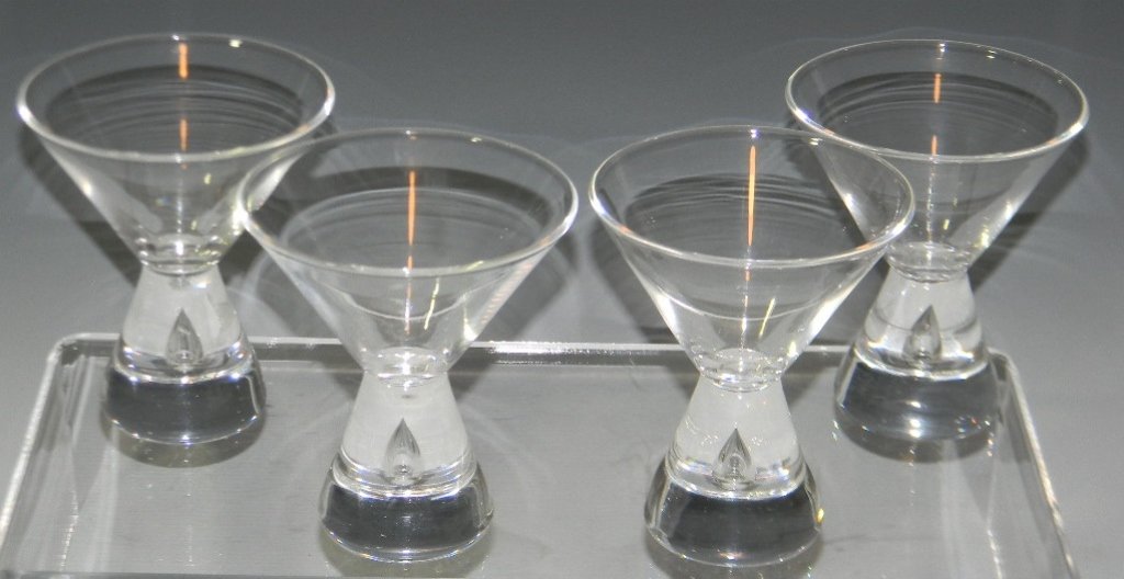 4 STEUBEN GLASS TEARDROP COCKTAIL GLASSES 7826: Four Steuben glass cocktail glasses of hourglass form with a teardrop shaped trapped air bubble to the stem, designed by George Thompson, etched signature on the foot, 3.875"h. PROVENANCE: Purchased c