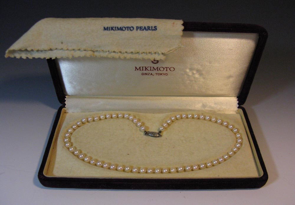 MIKIMOTO KNOTTED PEARL NECKLACE: A Mikimoto strand of sixty-two knotted 6mm pearls with a sterling silver clasp, 16"l and housed in the original presentation box. PROVENANCE: Purchased by our gentleman consignor while traveling throu