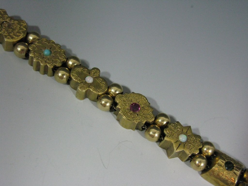 ANTIQUE 14K GOLD GEM SET SLIDE BRACELET: Victorian 14k Gold & Gemstone Slide Bracelet Eleven gold charms, each set with a cabochon gemstone (i.e. turquoise, opal, sapphires, garnet and emerald) alternating between two gold ball beads, stampe