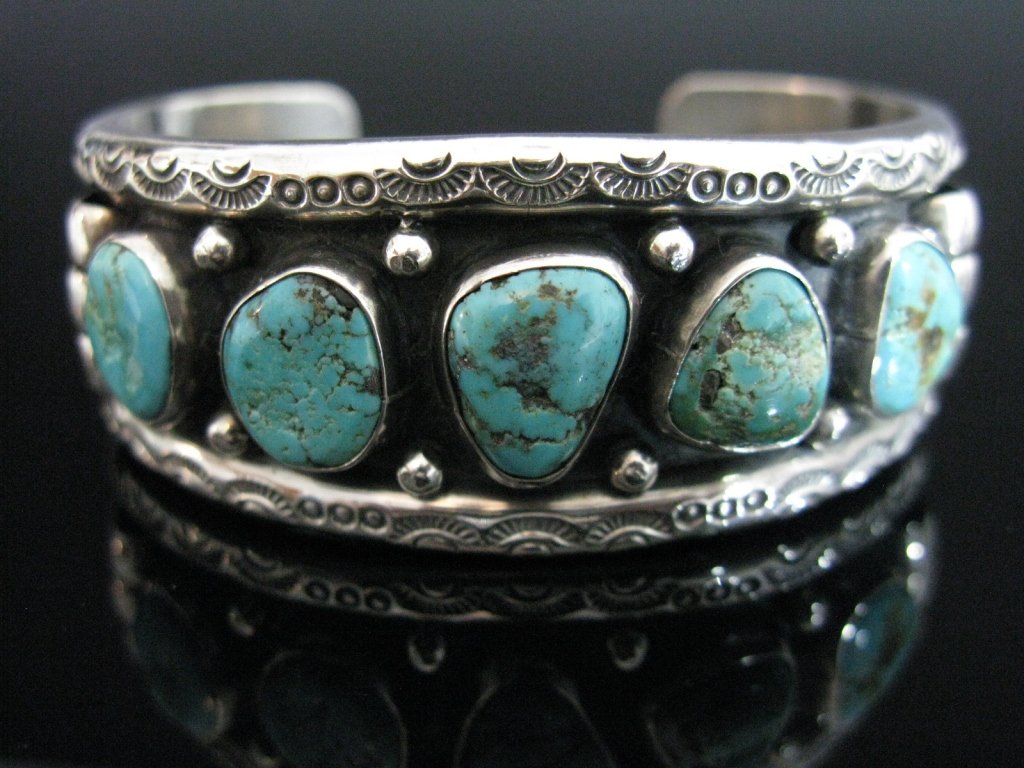 SIGNED NATIVE AMERICAN STERLING CUFF BRACELET: A vintage, Native American, sterling silver cuff bracelet mounted with five turquoise stones and adorned with silver balls, straps and impressed decoration, initialed "JB", possibly JB Cartier, 1"d x 