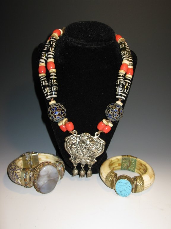 CHINESE REPOUSSE DRAGON NECKLACE & INDIAN CUFFS: Antique Chinese necklace with a central silver repousse pendant with the image of a dragon with orange glass beads, reticulated cloisonne "cash" beads and ceramic Dzi beads, and silver tones balls and