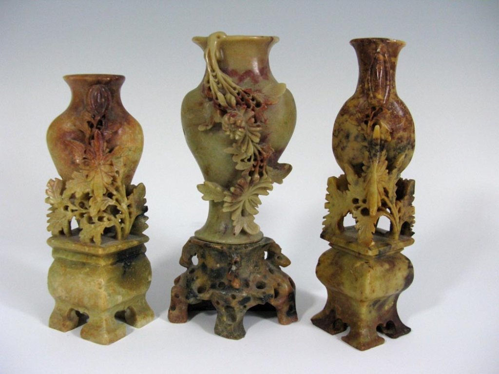 GARNITURE OF THREE CHINESE SOAPSTONE VASES: Three piece garniture of Chinese, carved soapstone vases. Each finely carved with blooming flowers, c. 1890, 5.75"h and 5"h. Ref: Soapstone, L-W Book Sales, 1995. PROVENANCE: From an established colle