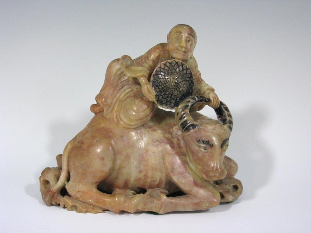 c. 1895 CHINESE PINK SOAPSTONE CARVING MAN ON OX: Circa 1895 Chinese carved and polychrome carving in pink soapstone of a man on a seated ox, well carved in the round, 5.5"h x 6.75"l. Ref: Soapstone, L-W Book Sales, 1995. PROVENANCE: From an establis