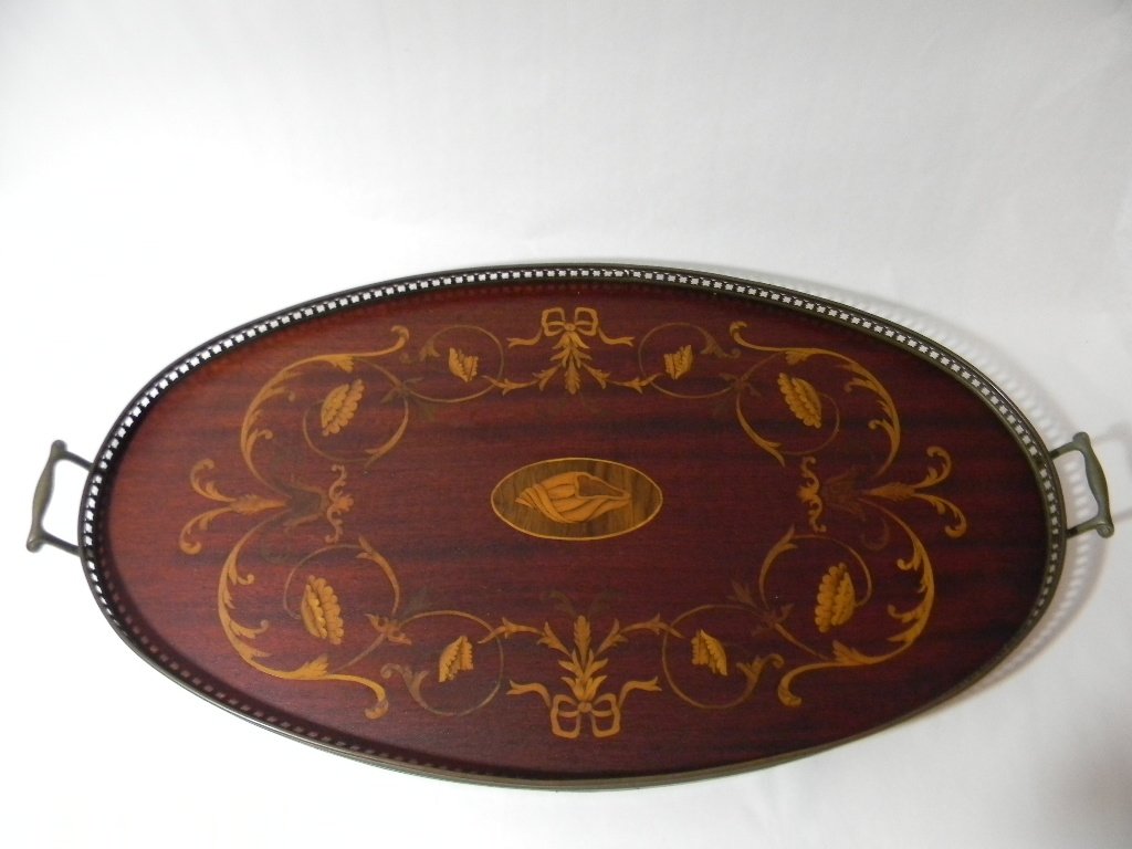 OVAL ENGLISH INLAID WOOD BUTLERS SERVING TRAY: An antique, oval, English butler's serving tray with a metal gallery and handles. This example inlaid with a seashell and surrounded by delicately inlaid scrolling vines, flowers and ribbons. 14.75"h 