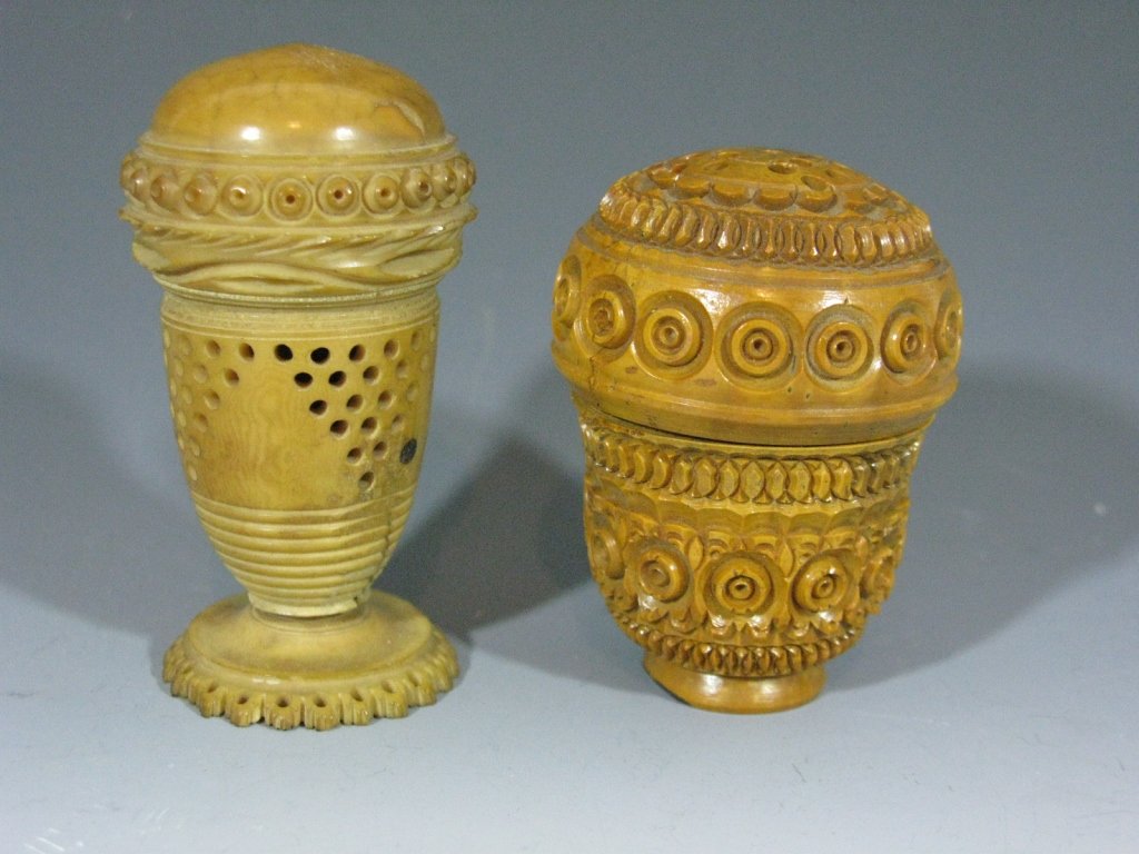 CARVED COQUILLA NUT NUTMEG GRATERS / POMANDERS: Pair of 19th century Coquilla Nut (a.k.a. vegetable and faux ivory, tagua) carved vessels, one a pomander and one with piercing, 3"h and 2.5"h. PROVENANCE: directly from the lifetime collection and es
