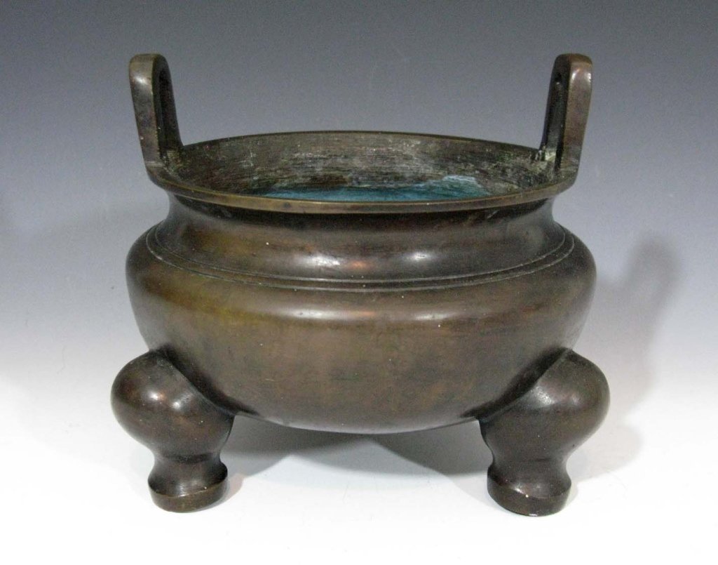 CHINESE XUANDE MARKED TRI-FOOTED BRONZE CENSER: Chinese tri-footed bronze censer of ding form, raised upon three feet and with raised handles, 6"h x 6.75"d, Xuande (1426-1435) reign mark on base. 6lbs 8oz. PROVENANCE: directly from the lifetime col