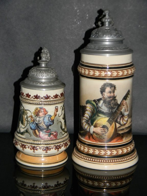 2 @ C. 1900 EXQUISITE HAND PAINTED GERMAN STEINS: Pair of German Ceramic Beer Steins with Pewter Lids, c. 1900. 1.) .3L. with fully hand-painted image of a woman with a glass of beer and a lute surrounded by sprays of hops, Pewter lid marked: Reichs 