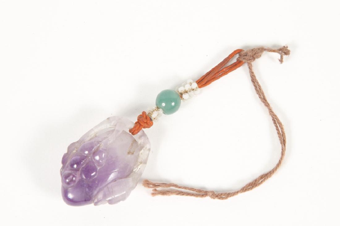 Antique Chinese Carved Crystal Pendant: 19th or early 20th century. Lavender stone in the shape of a fruit, having a strung glass and jade tassel. Good condition overall with some surface scuffs consistent with age. L 3 1/2" including rope 