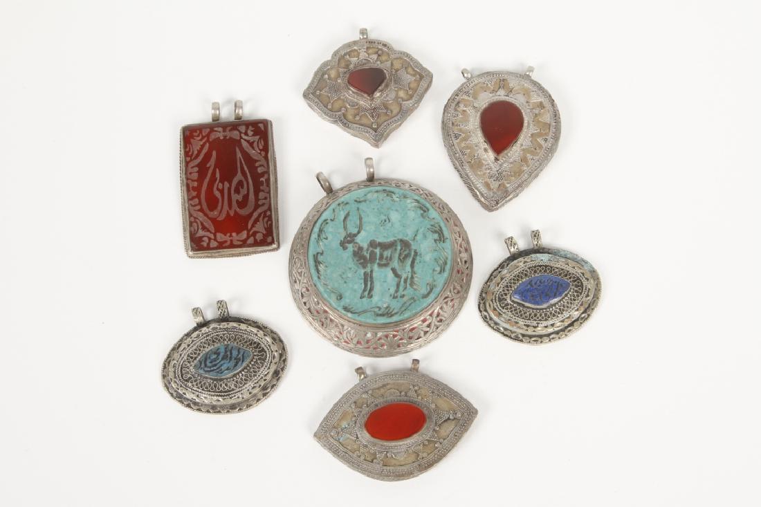 Collection Vintage Oriental Silver & Stone Pendant: Early 20th century. Consisting of seven interesting handmade pendants each centered with various stones. Good overall condition with some scattered wear consistent with use and age.