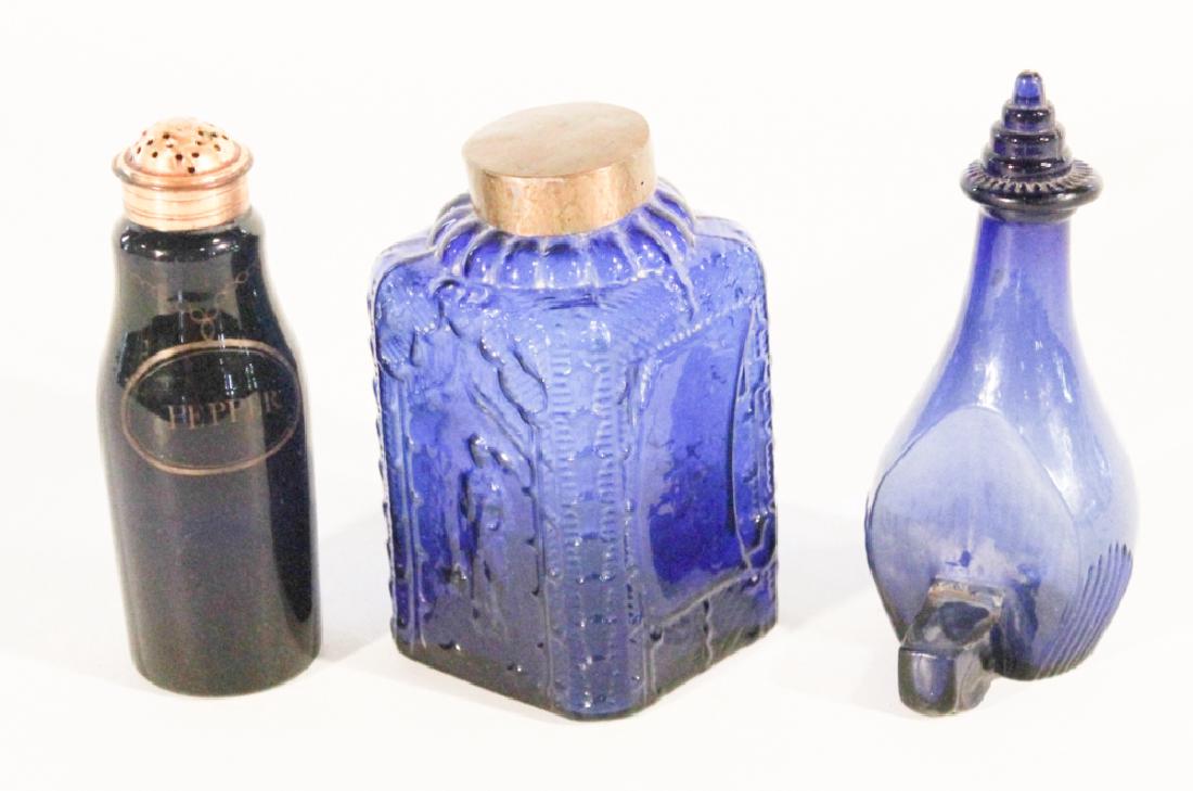 Three Antique Blown Cobalt Blue Glass Articles: 19th century. Consisting of a pepper caster, a tea caddy and an unusual oil lamp. Good overall condition with minor wear to feet and surface. Tallest: H5 7/8"