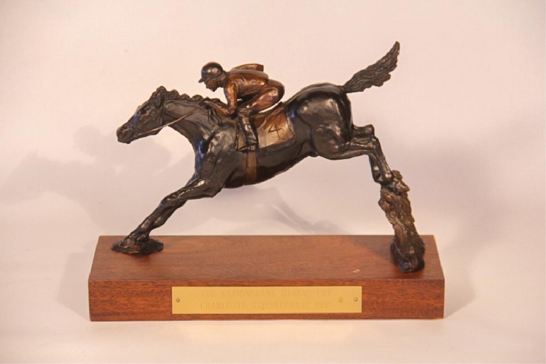 Dedi McHam: (North Carolina, 20th century) Steeplechase bronze trophy figure for The Nationsbank Queen's Cup Charlotte, NC Steeplechase 1998. The figure is handsomely cast and depicts a horse and rider clearing a