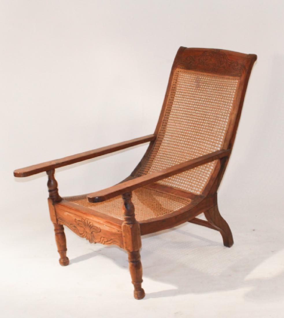 Antique Plantation or Planters Chair: Mid 19th century, Caribbean or West Indies. Having long arms with carved back rest centered by woven cane seat and back. Mortised and pegged construction throughout. Good sturdy condition. H27 1/2" W2