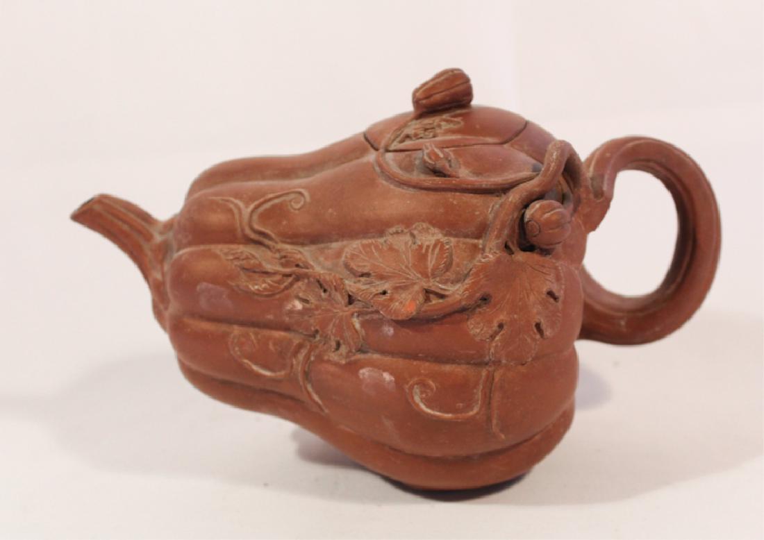 Antique Japanese Earthenware Gourd Form Teapot: 19th century. Having an excellent form with vine handle and leaves in relief at the side. Very small nick to one leaf but overall very good condition. Marked by the maker at the underside of the lid. 