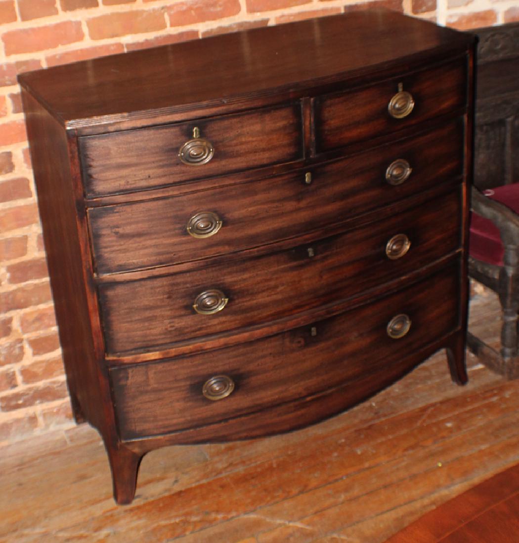 George III Mahogany Bow Front Chest of Drawers: Circa 1810, Britain. Having a reeded edge at the top above two over three drawer configuration resting atop French feet. H41 1/4" W42 1/2" D20"