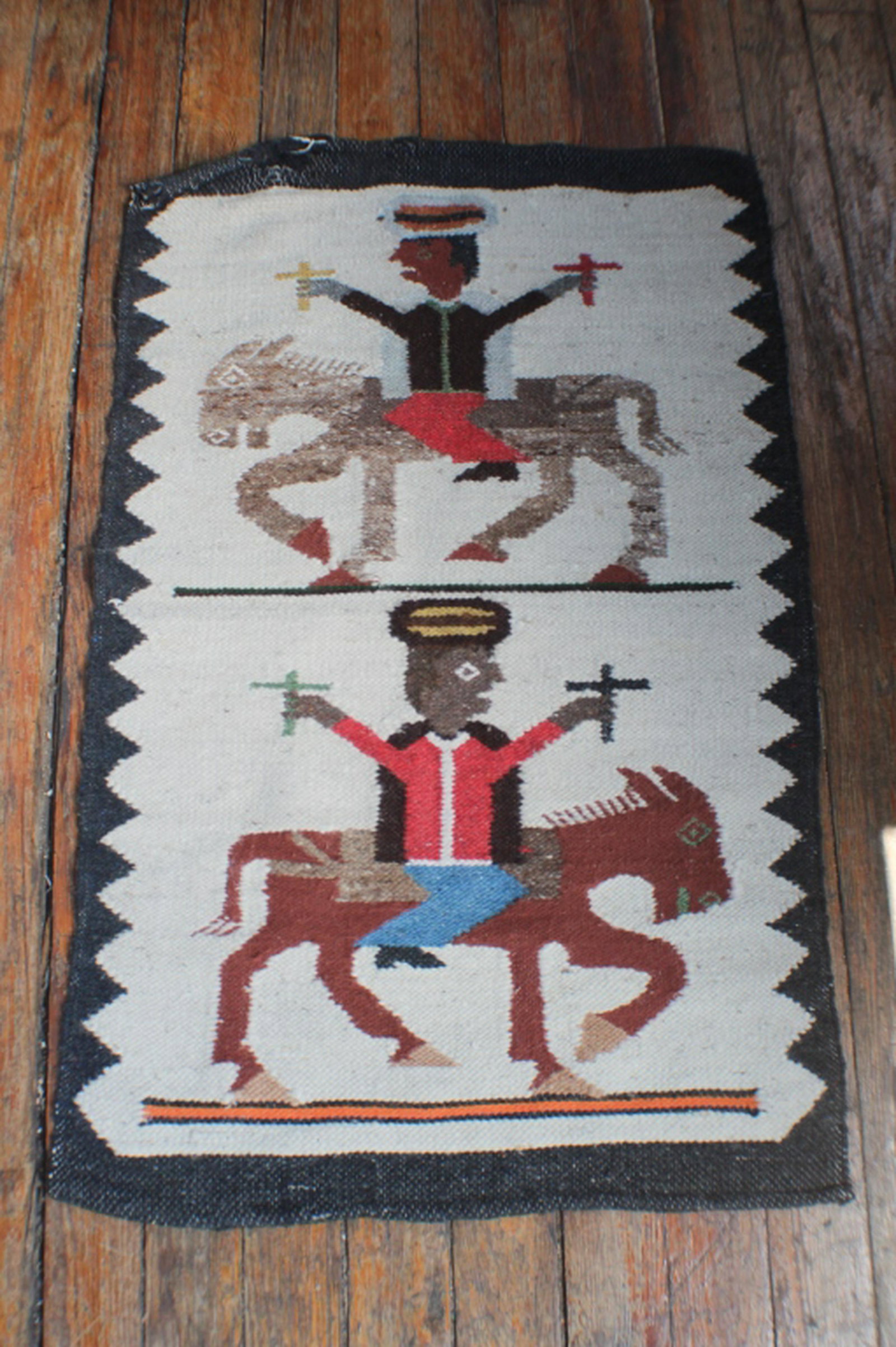 Interesting Wool Woven Pictorial Horse Blanket: 20th century, likely South or Central American. The piece depicting two men on horseback with crosses in hand. Good condition some slight fraying to upper left hand end. H40 1/2" W25"