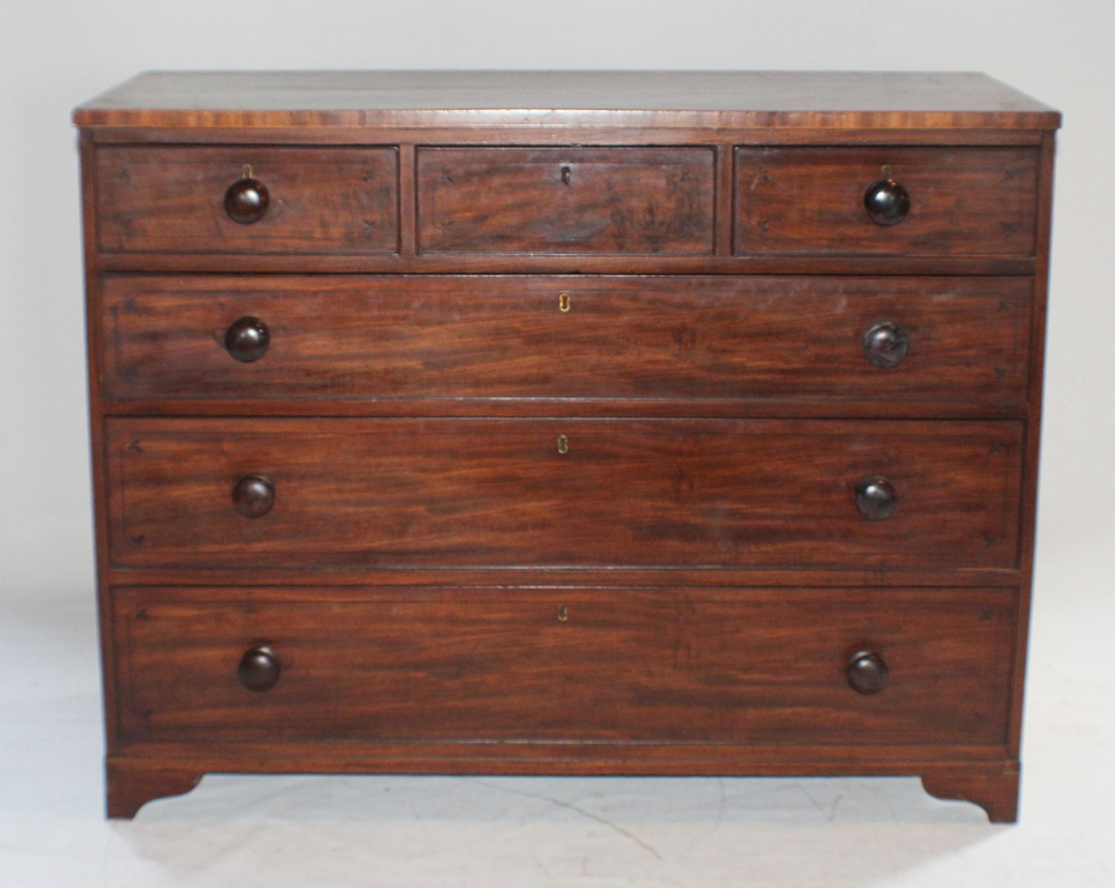 George III Inlaid Mahogany Chest of Drawers: Circa 1810, Britain. Having a rectangular top above three over three drawer configuration each of which has nicely banded ebony inlay. All resting atop bracket foot. H37 1/2" W48 1/2" D21 1/2" Sold fr