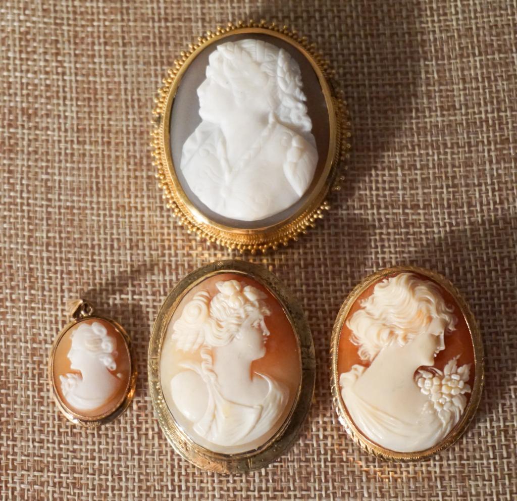 Antique Carved Shell Victorian Cameo Brooches: 14k gold. The group includes three shell carved cameos featuring Grecian style ladies, along with a single stone agate and marble carved cameo featuring a lady of the 19th century. Each housed in oval