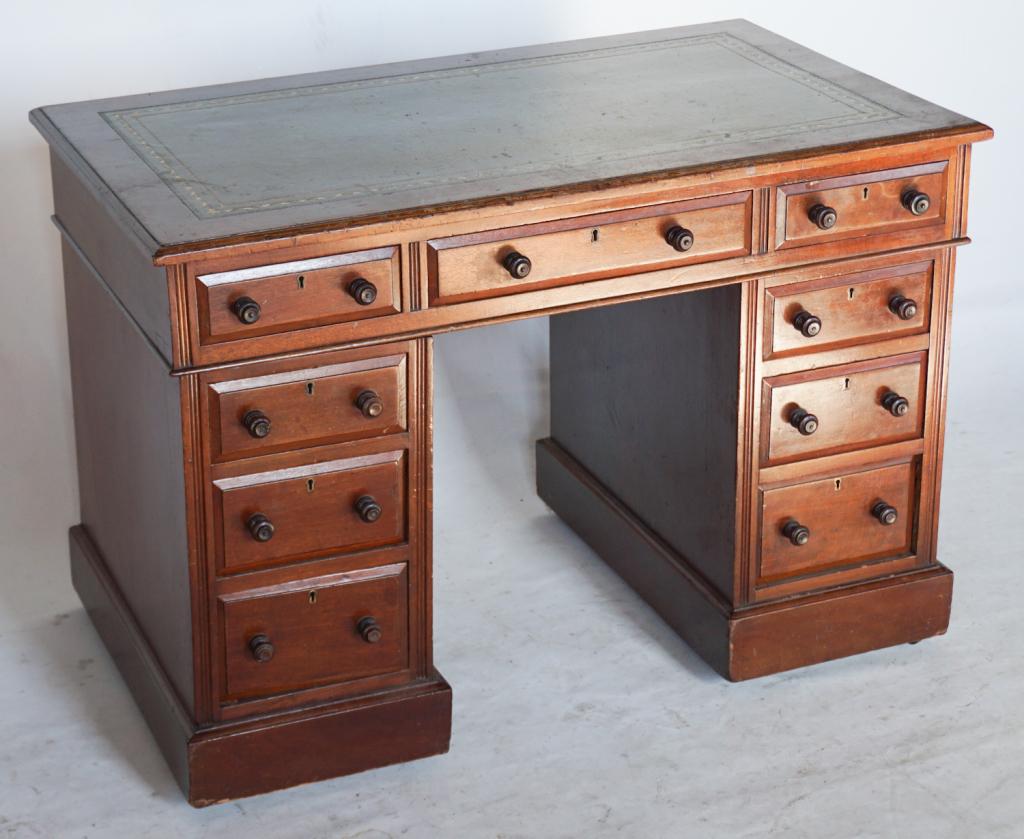 British Regency Mahogany Diminutive Partners Desk: Circa 1830. Having a handsome leather top with rectangular form and molded edge above two lower case supports housing three drawers and having reeding at each side above a molded base on casters. Perh