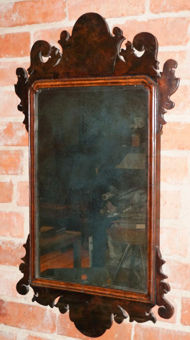 George III Mahogany Mirror or Looking Glass: Circa 1800. Having a scrolling frame with early beveled glass mirror. Some minimal losses to border of the mirrorÕs frame, some slight veneer loss at left side top and bottom. H30" W16 1/2" Sold from