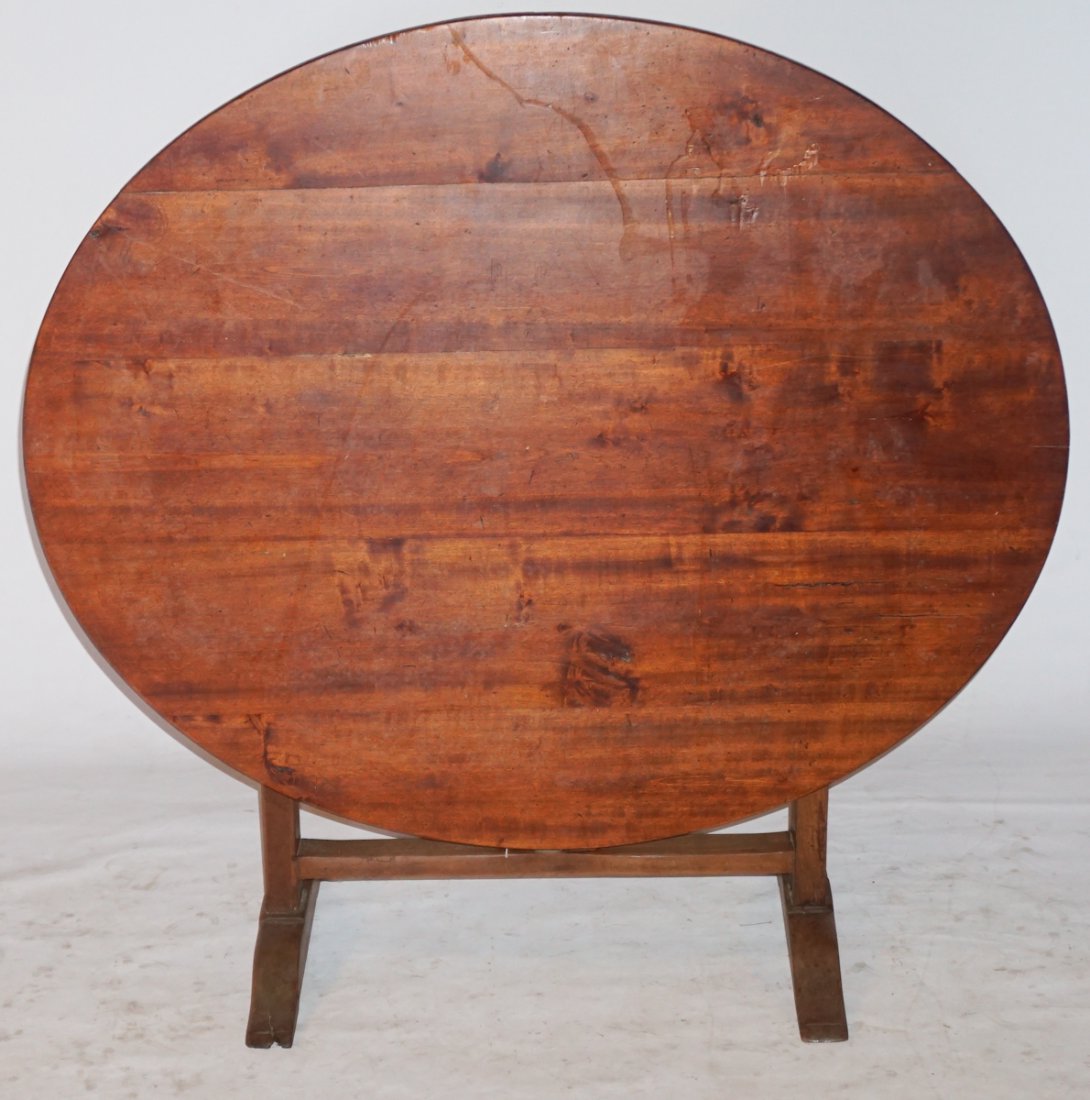 French Provincial Walnut Wine Tasting Table: Circa 1800. Having a slightly oval top with trestle type base having nicely shaped rotating support for top. The piece sits nice and even. Sturdy table. W47" H28" Sold from the collection of Mrs. Joan