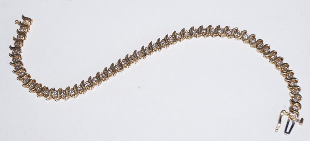 10k Diamond & Gold Tennis Bracelet: 2 ctw of round cut diamonds inset into elegant gold links with a rope type style. 8.4 grams. All jewelry lots in the auction have been professionally examined by a jeweler and authenticated. L7 1/4"