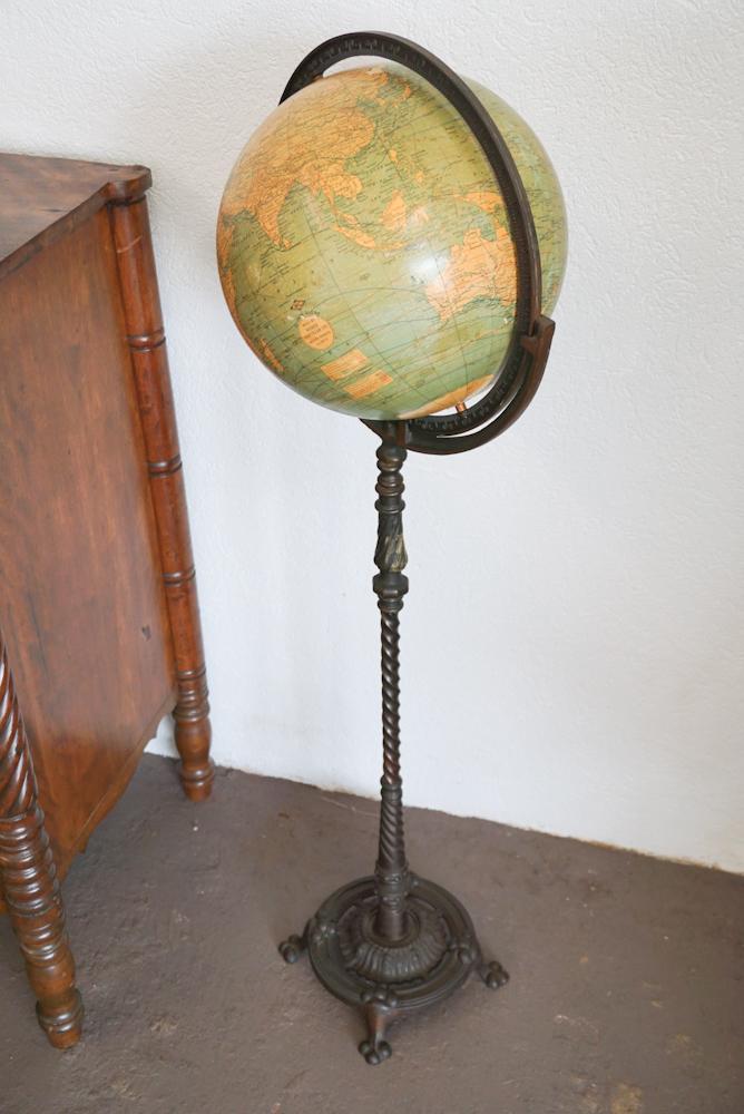 Arts & Crafts Period Webber Globe on Iron Stand: Circa 1900. Having a handsomely cast and patinated iron base marked MG at underside. The globe in good overall condition with some slight yellowing to paper and minor nicks to surface. H47"
