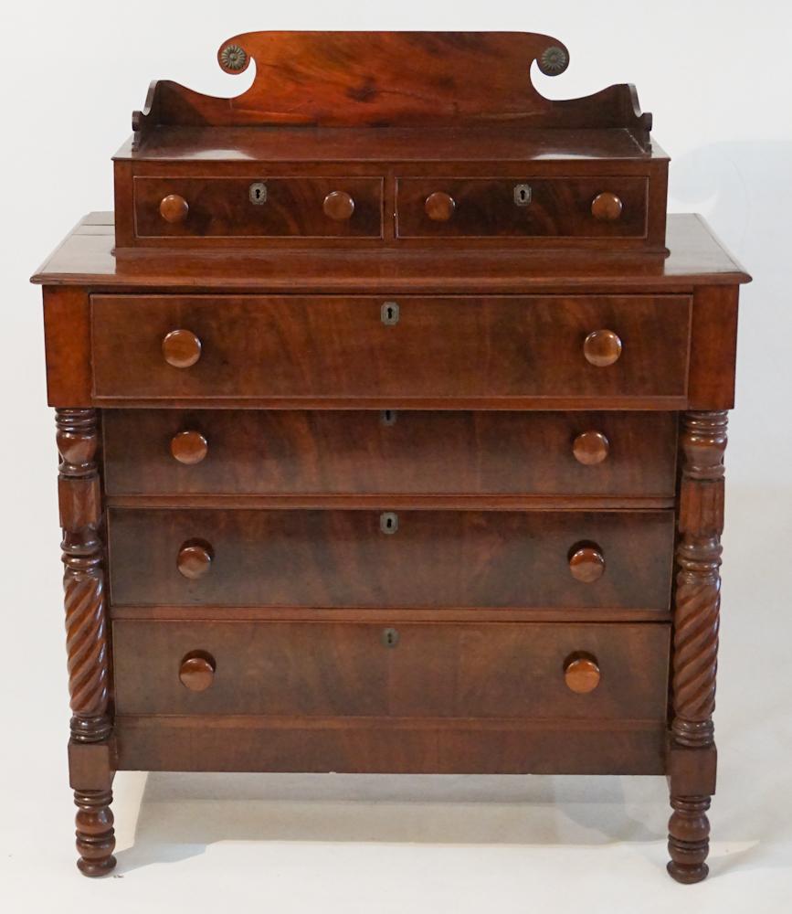 American Late Federal Mahogany Chest of Drawers: Circa 1820. Having a shaped backsplash with nicely cast brass rosettes leading down to two drawers above four graduated drawers flanked by turned and spiral carved half columns all resting on a turned