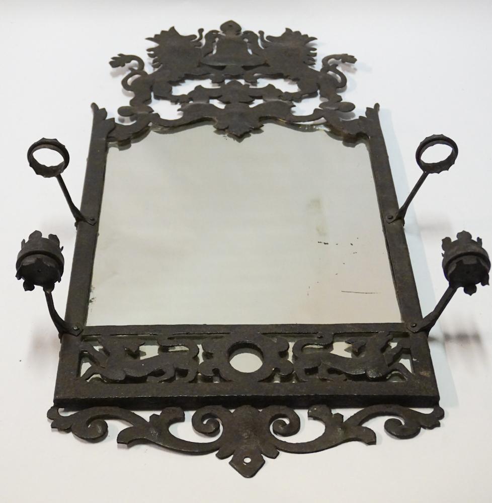 Hammered & Cut Metal Spanish Style Looking Glass: Circa 1890, likely Mexico or Central America. The piece has a fine form with lion crest at upper frame leading down to looking glass housed in the frame flanked by sturdy and well placed candle holder