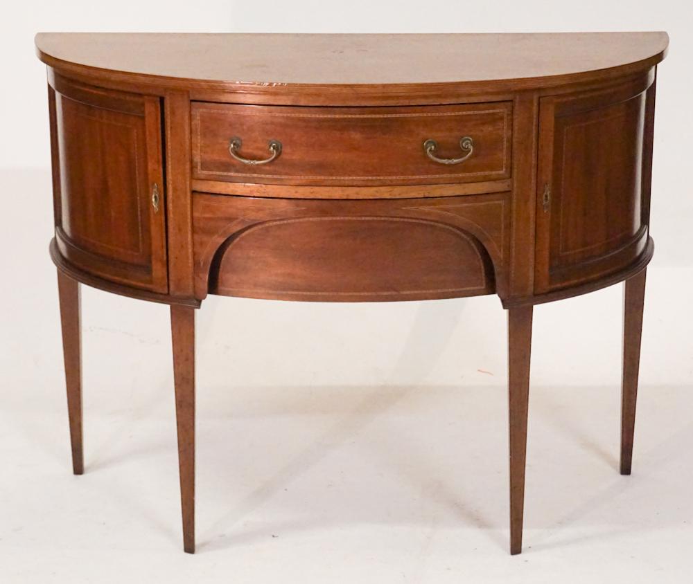 Edwardian Style Inlaid Mahogany Brandy Board: Early 20th century. Having a demilune form with nicely inlaid top above well banded case housing two drawers at center flanked by hinged doors at each side atop nicely inlaid and tapered legs. H36" W4