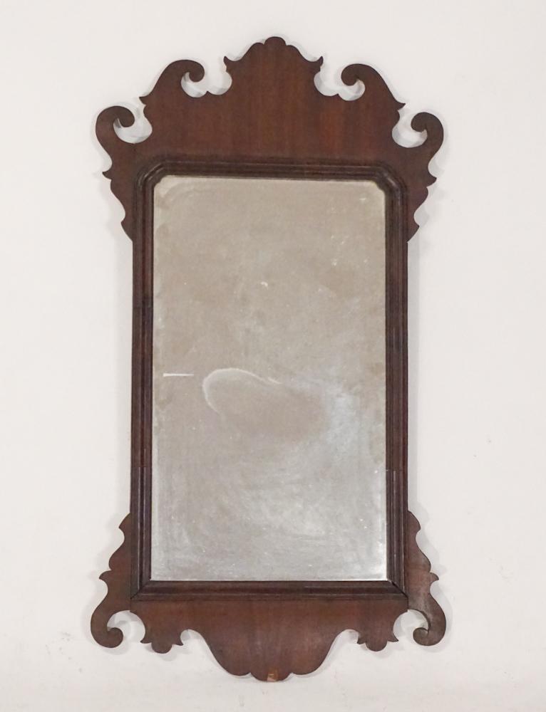 George III Mahogany Looking Glass or Mirror: Circa 1810. Having a nicely shaped frame with well figured veneer and centered by early glass. Scattered shrinkage and slight loss to veneer at lower middle segment. H31 3/4" W17 1/4"