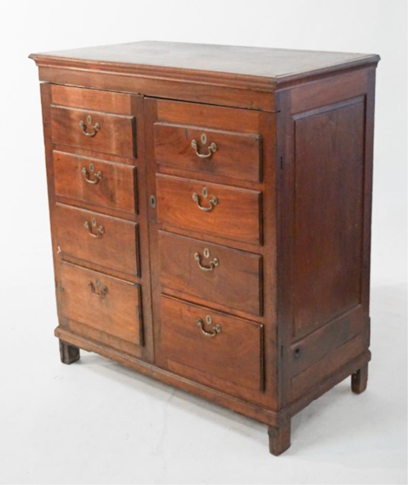 Uncommon George III Mahogany Low Linen Press: Circa 1810. Having a rectangular top with molded edge above two hinged doors with faux drawer fronts and brass pulls opening to interior housing three shelves within and the case resting atop a square