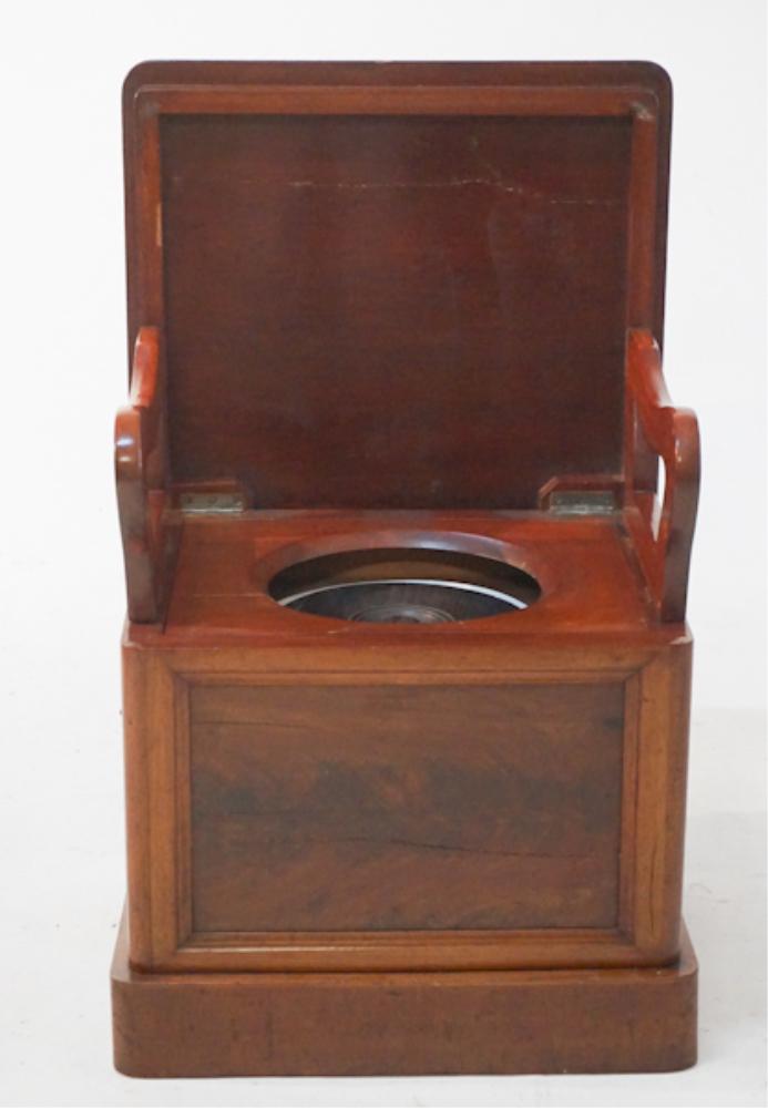 Antique Victorian Upholstered Lift Top Potty: Mid 19th century, likely British. The piece has a nicely upholstered suede top with shaped edge hinged to open to lowercase housing porcelain chamber pot all resting on casters. H18 1/2" W19 1/2" D22"