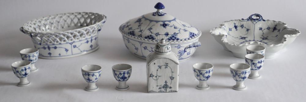 Royal Copenhagen Blue Lace Fluted Table Wares: Early to mid 20th century, Denmark. The collection includes a fine lidded serving bowl, center bowl with reticulated edge lidded tea caddy, eight egg cups. All in good well kept condition throughout.