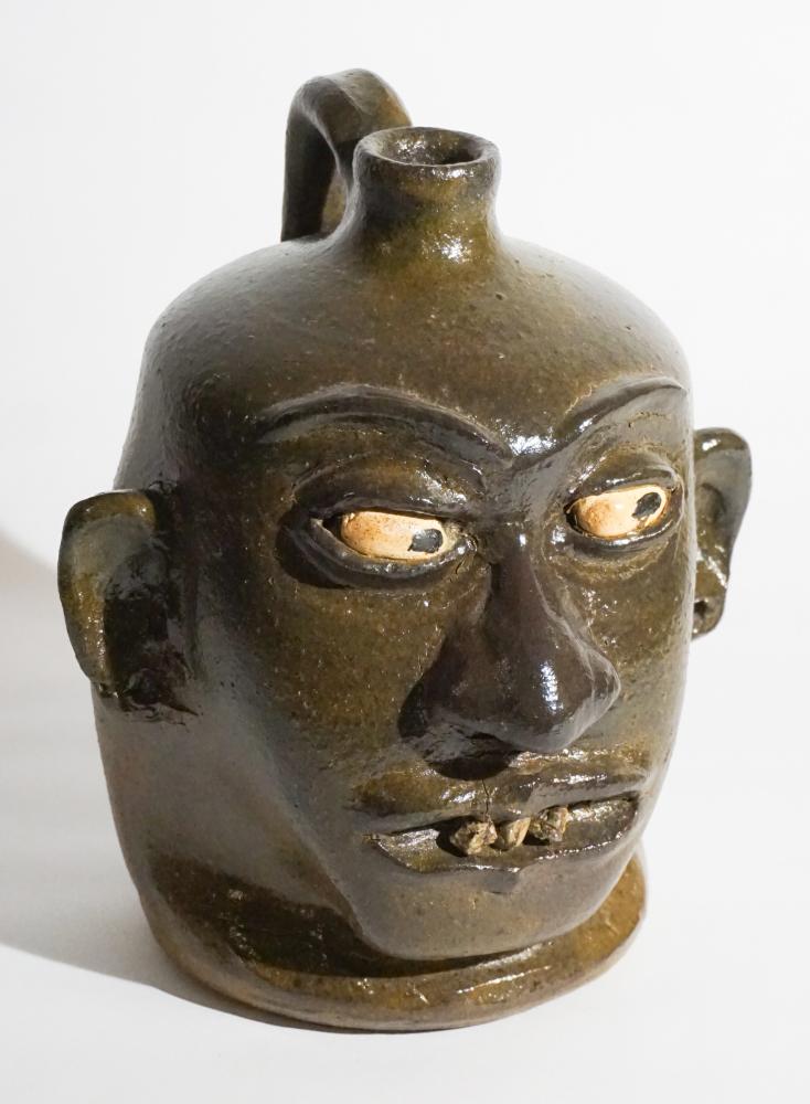 Excellent Southern Stoneware Rock Tooth Face Jug: Lanier Meaders working in Mossy Creek, Georgia (1917 -1998) Very fine, well sculpted and richly glazed example. The piece having rock teeth and well defined facial features. Signed at the underside by