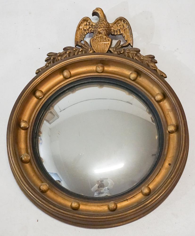 Handsome Federal Style Bullseye Mirror: Circa 1880. Having an eagle at top above lower porthole style frame surrounded by orbs one of which is not present and with convex mirror at the center. H21" W17" Sold from the collection of a Wilming