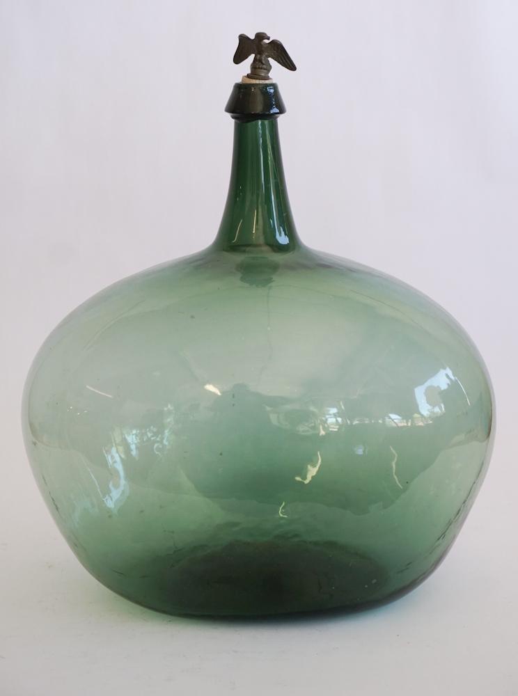 Antique Blown Glass Wine Bottle with Eagle Stopper: Likely 19th century European origin. The ovoid blown glass bottle has an early porcelain and brass eagle stopper at top. Good condition with some wear to foot as expected for age. 19 1/2" Sold from th