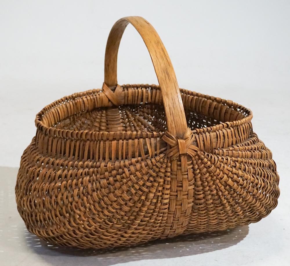 Tennessee Woven Split Wood Buttox Basket: Very well crafted example having been precisely crafted with a sturdy and delicate weave. Very good condition throughout. The piece has a tag reading it is from 1963. Good condition throughout. H18" D