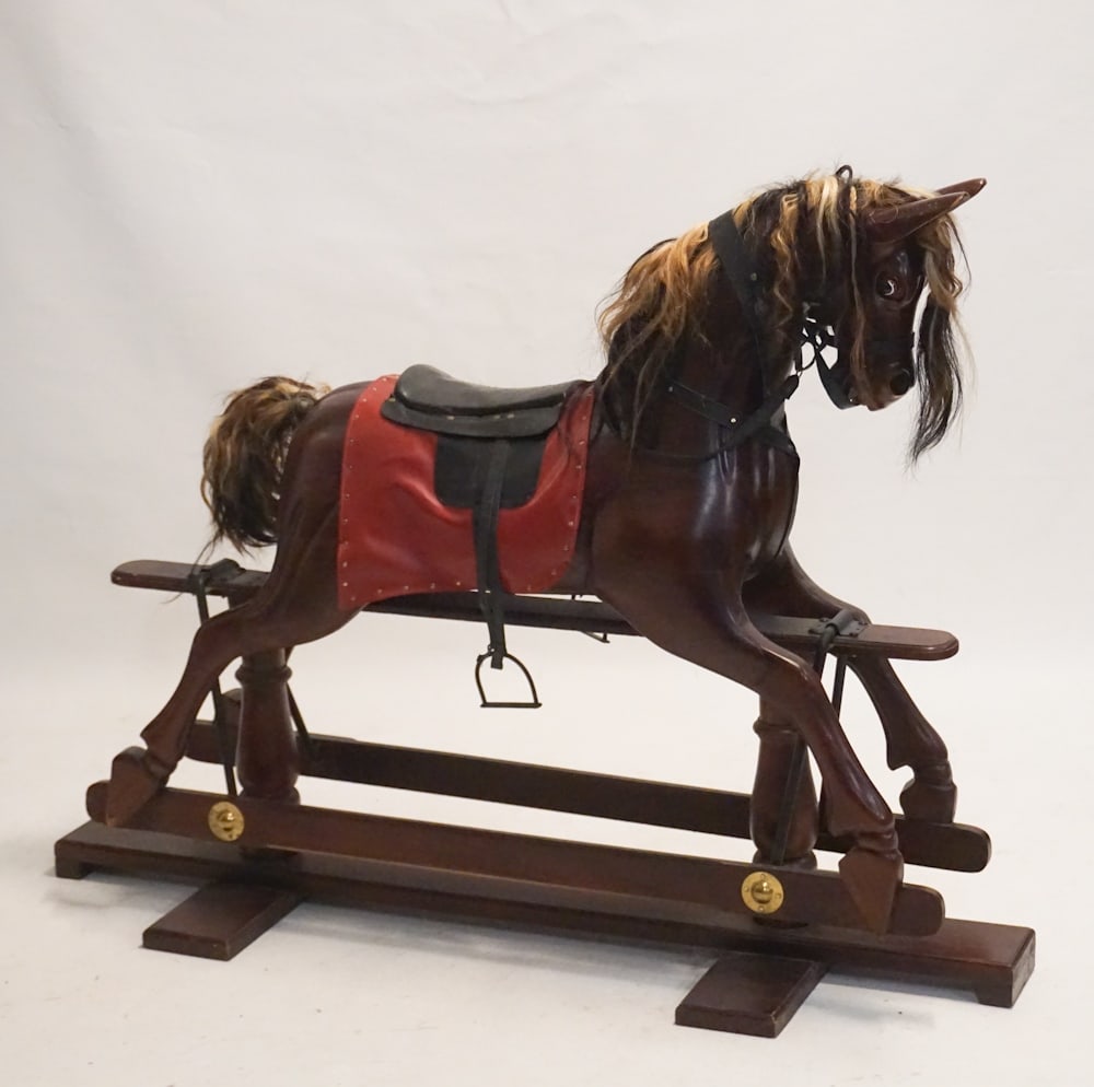 English Carved Wood Childs Rocking Horse: 20th century. High style example having natural horse hair mane and tail with nicely carved body and sturdy glider mechanism attached to base. Well functioning example in good overall condition. H44 1