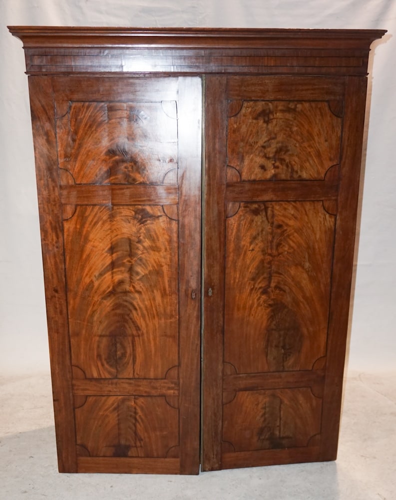 George III Figured & Inlaid Mahogany Wardrobe: Circa 1810, Britain. Having a molded crown above two hinged doors all ebony inlaid and figured very nicely with rich grain. H68 5/8" W51 1/8" D23 1/8" Sold from the collection of Jean and Steven Rothr
